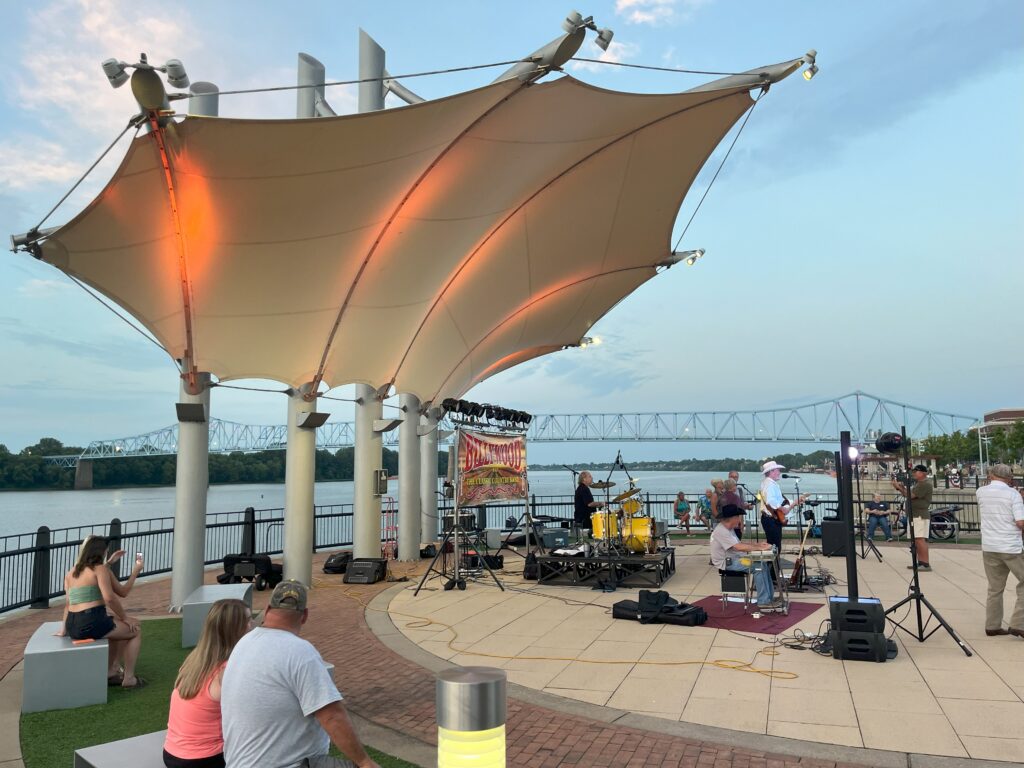 A music act plays under a bandshell on the riverfront during Friday After 5.